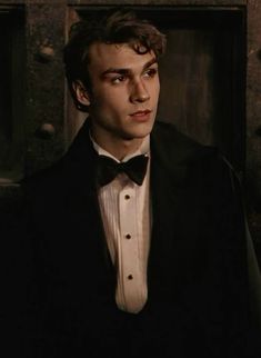 a young man in a tuxedo and bow tie looking at the camera with an intense look on his face