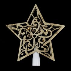 a decorative wooden star ornament hanging from a white candle holder on a black background