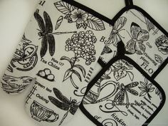 three oven mitts with black and white designs on them