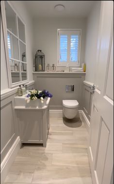 a white toilet sitting next to a window in a bathroom