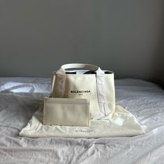 Balenciaga Small Cabas Totebag/Handbag - Color: Off-White/Cream - Material: Cotton Canvas, Smooth Calfskin - Size: 18.5'' W X 9.4'' H X 7.4'' D / Handle Drop 6.5" / Pouch Strap Length 12.00" - Features: Open Top, Side Snaps, 1 Inner Zipped Pocket, 1 Inner Detachable Pouch, Leather Reinforcement, Laser Perforated Logo At Front - Care: Wipe With A Soft Cloth - Made In Italy - Includes: Original Dust Bag, Detachable Pouch - Description/Details: This Is An Authentic Balenciaga Cotton Canvas Calfskin Cabas Small In Off-White. This Impressive Tote Is Crafted Of A Fine Ivory Canvas. The Top Is Open To A Coarse Black Linen Interior With A Matching Companion Pouch. *Condition: Used-Fair Condition Black Linen, Cotton Tote Bags, Womens Tote Bags, Calf Skin, Balenciaga, Wood Signs, Cotton Canvas, Dust Bag, Pouch