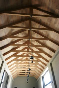 an empty room with wooden ceiling and windows