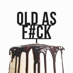 a cake with chocolate drizzle and the words old as e / gk on it