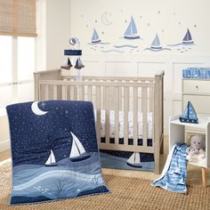 a baby's room decorated in blue and white with sailboats on the wall