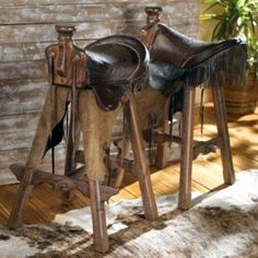 there are three metal horse saddles on display