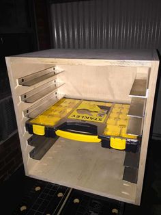 the inside of a storage container with tools in it and yellow boxes on the floor