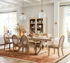 a dining room table with chairs and a rug on the floor in front of it