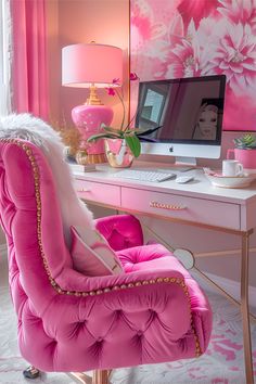 a pink chair sitting in front of a desk with a computer on top of it