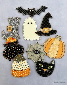 a collection of halloween appliques are arranged on a gray surface with black and orange accents