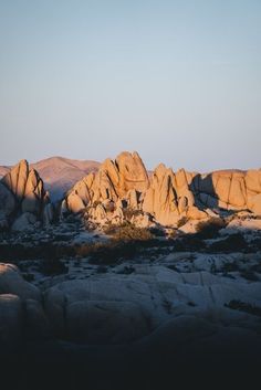 the sun is setting on some rocks in the desert