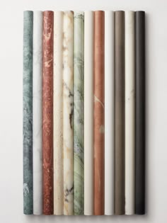 an assortment of different colored marbles on a white wall