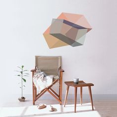 a chair and table in a room with a wall hanging on the wall behind it