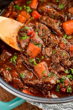 a pot filled with beef stew and carrots