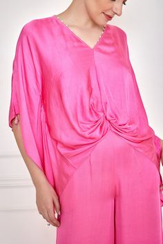 Dopamine pink draped kaftan with pearl and feather tassel detailing on neckline and hem. Paired with jumpsuit.
Components: 2
Pattern: Embroidery
Type Of Work: Pearl, feather tassel
Neckline: V neck
Sleeve Type: Kaftan sleeves
Fabric: Cotton Satin
Color: Pink
Other Details: 
Cinched on the waist
Crystal drops sleeve hem
Flared bottom
Occasion: Cocktail - Aza Fashions Elegant Pink Viscose Blouse, Elegant Viscose Kaftan, Short Sleeve Kaftan For Party, Pink V-neck Kaftan For Evening, Evening Kaftan With Tassels, Pink Kaftan For Spring Evening, Pink Evening Kaftan For Spring, Elegant Pink V-neck Kaftan, Draped Kaftan