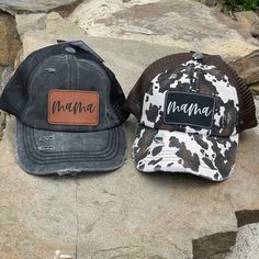 two hats sitting on top of a rock next to each other, one with the word mama written on it