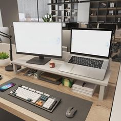 two computer monitors sitting on top of a desk next to a mouse pad and keyboard