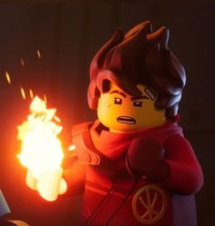 a lego man holding a lit candle in his hand with flames coming out of it