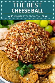 the best cheese ball on a plate with crackers and grapes