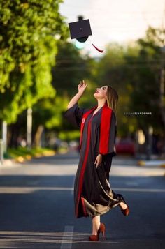 a woman in graduation gown tossing a cap into the air with her hands and feet