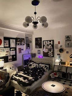 a bed room with a neatly made bed and lots of pictures on the wall above it