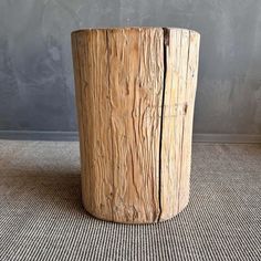 a large wooden stump sitting on top of a carpeted floor