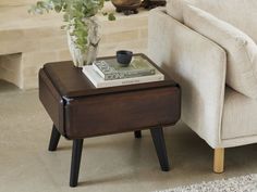 a coffee table with a book on it next to a couch