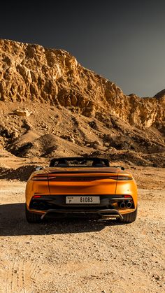 an orange sports car parked in the desert