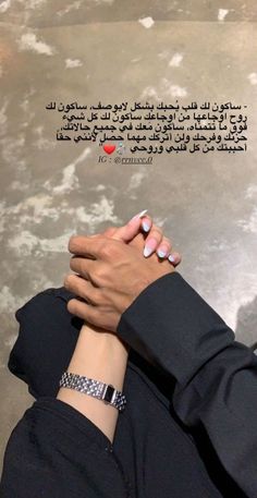 two people are holding hands with an arabic quote in the background, and one person has their hand on the other's wrist