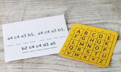 a yellow and black keyboard sitting on top of a wooden table next to a piece of paper