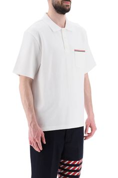 Thom Browne polo shirt crafted in solid pure cotton jersey. Design with spread collar and three-button half placket featuring a chest patch pocket decorated with tricolor band, dropped back hem with buttoned slits finished with tricolor grosgrain. Embellished with tricolor loop tab on the upper-back. Relaxed fit. The model is 187 cm tall and wears size 3 Thom Browne. Size Info MONCLER Color Detail White Made In Japan Material 100% CO Season One spring Season Two summer Product clothing Brand Tho Classic Polo T-shirt With Striped Collar, Classic Short Sleeve Polo Sweater With Striped Collar, Classic White Tops With Patch Pockets, White Johnny Collar Polo Shirt With Placket, White Polo Shirt With Johnny Collar, White Johnny Collar Polo Shirt, Classic Cotton Polo Sweater With Striped Collar, White Polo Shirt With Pockets, Classic Polo Shirt With Striped Johnny Collar