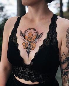 a woman with tattoos on her chest wearing a bra