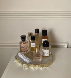 an assortment of perfume bottles sitting on top of a table