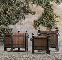 three wooden planters sitting next to each other in front of a wall with ivy growing on it