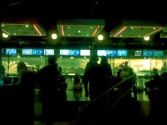 some people are standing in front of a building with many windows and lights at night