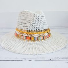 This hat is a total vibe. one of my favorites to keep the sun away and look fab while your doing it.  This hat is one size fits most and comes with an inner drawstring to make the hat smaller if need be.   All hats come customized like in the picture but you do have the option to choose what color trim you would like above the row of shells. White Bohemian Brimmed Sun Hat, White Fedora For Beach With Short Brim, Trendy Flat Brim Sun Hat For Festival, White Bohemian Straw Hat For Vacation, White Beach Fedora With Short Brim, White Wide Brim Fedora For Beach, White Fedora For Beach Season Vacation, Casual White Hat Band For The Beach, White Fedora For Beach Vacation