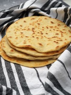 three pita breads on a black and white towel