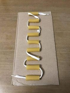 some yellow and white toothbrushes in a box on a wooden table with string