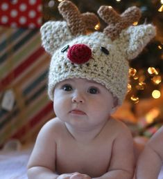 a baby wearing a crocheted reindeer hat