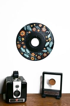 there is a black and white donut on the wall next to an old camera