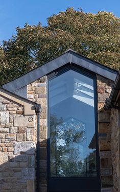 the corner of a building with a skylight on it's roof and trees in the background