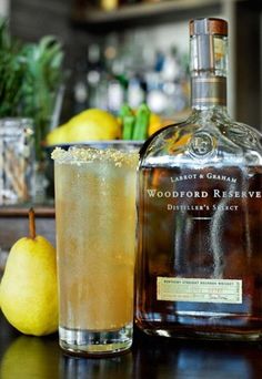 a bottle of woodford reserve next to a glass filled with ice and lemons