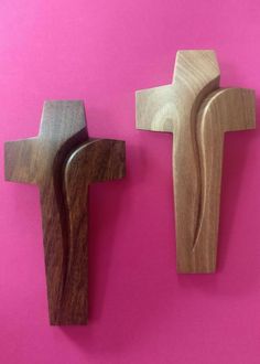 two wooden crosses on a pink background