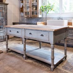 an old fashioned kitchen island with drawers in the center and a sink on one side