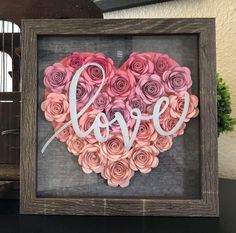 a heart made out of pink roses with the word love