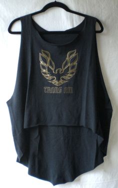 a black crop top with gold wings on it and the words trans am written in gold