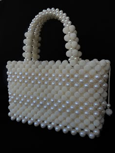 a white purse with pearls hanging from it