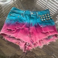 a pair of pink and blue shorts with rivets