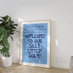 a blue sign that says welcome to our silly little dormr next to a potted plant