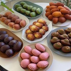 there are many different types of pastries on the table together, including macaroons and almonds