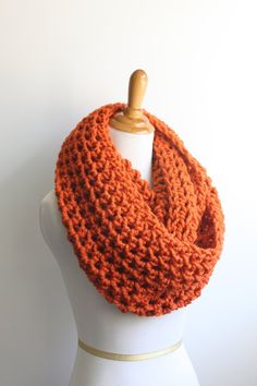 an orange crocheted scarf on a mannequin